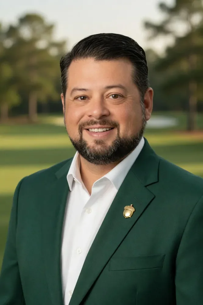 Professional portrait of Ruben Delgado in a dark green blazer and white shirt.