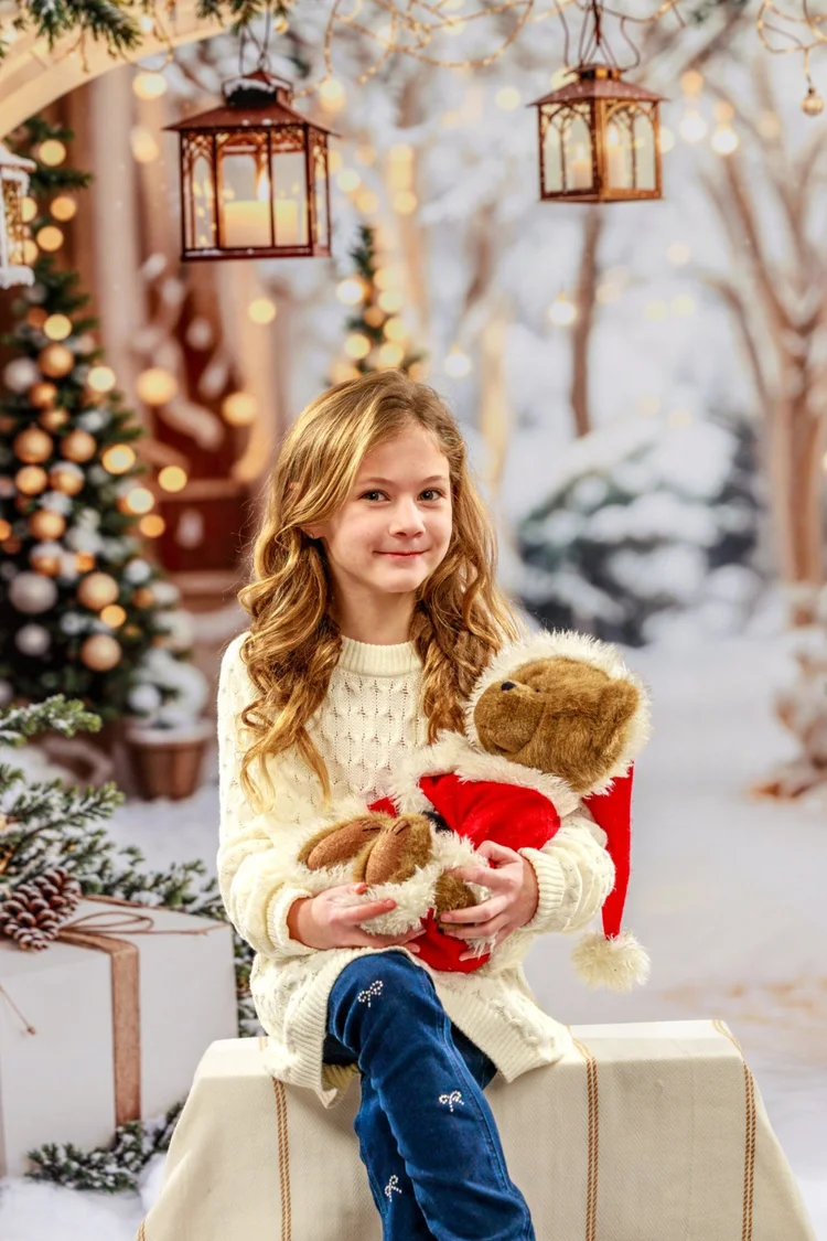 Child holding a teddy bear during a winter holiday portrait session