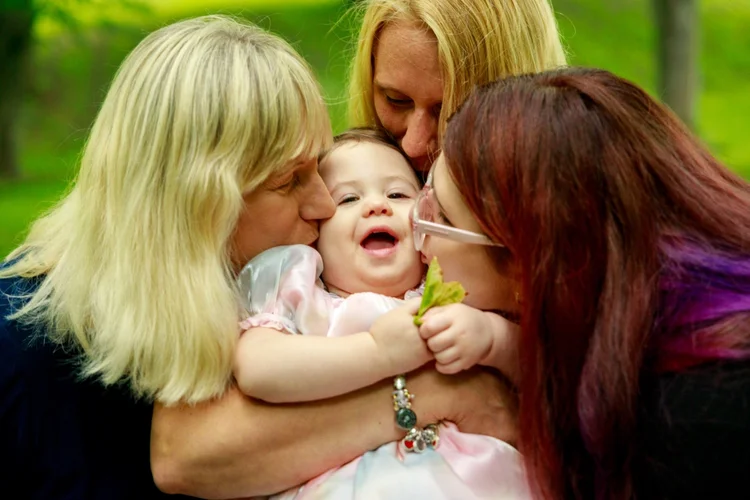 Family sharing an affectionate moment with a toddler outdoors