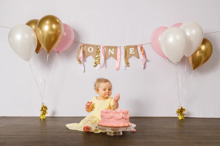 Baby exploring a birthday cake during a first birthday session