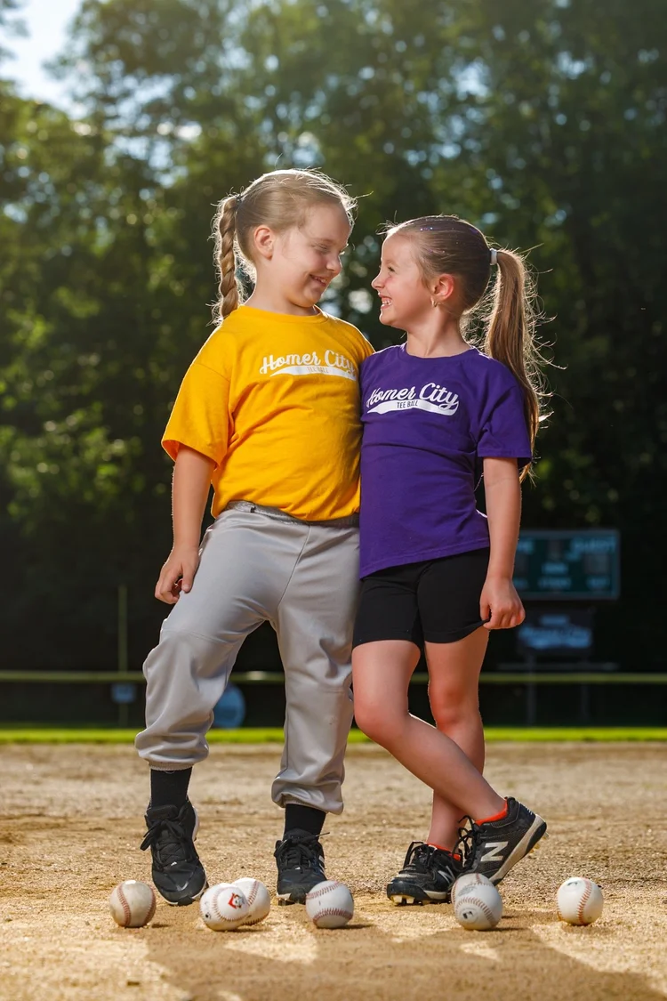 Youth baseball players sharing a playful moment on the field