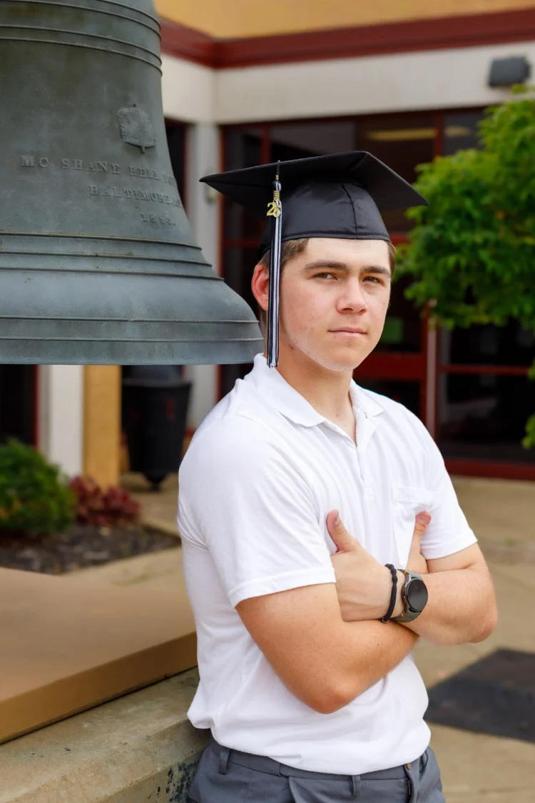 High school senior portrait beside a historic school bell