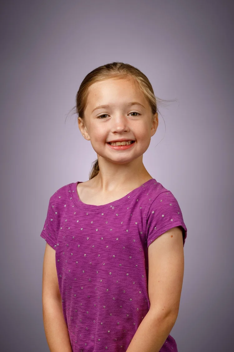Elementary school portrait on a soft purple background