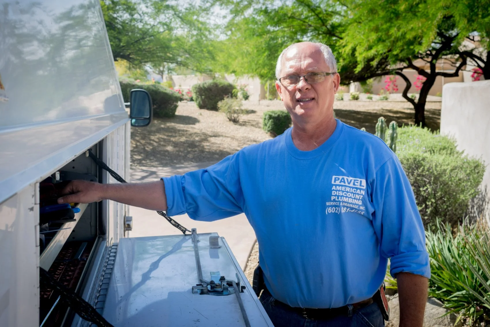 Pavel Farcas selecting a replacement part from the American Discount Plumbing service truck.