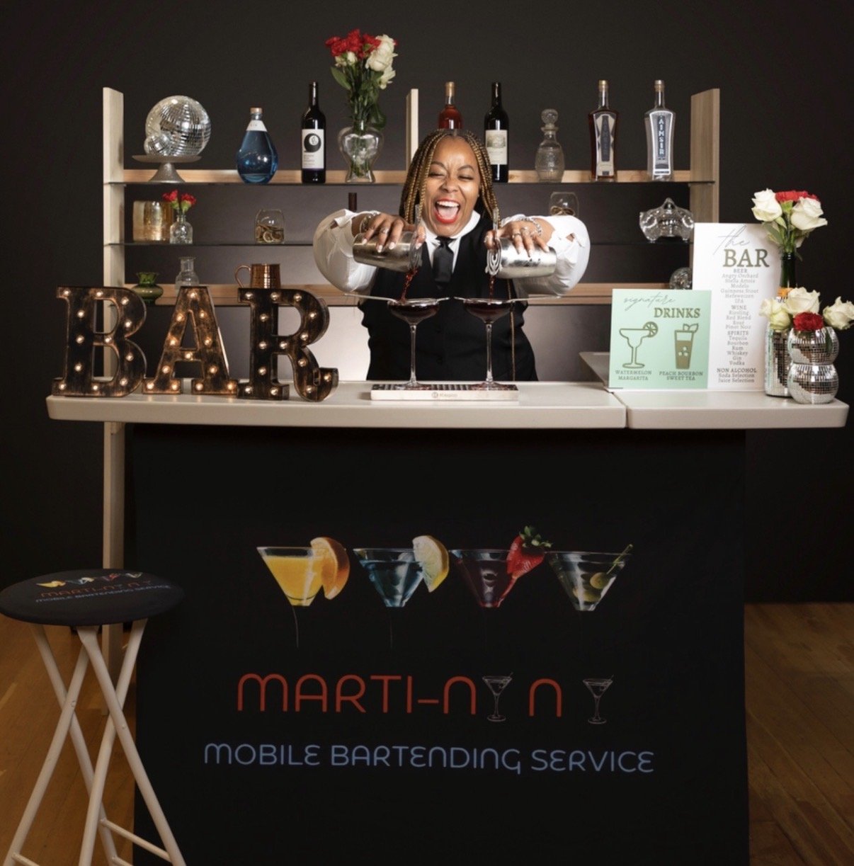 NiNi smiling while pouring two signature drinks