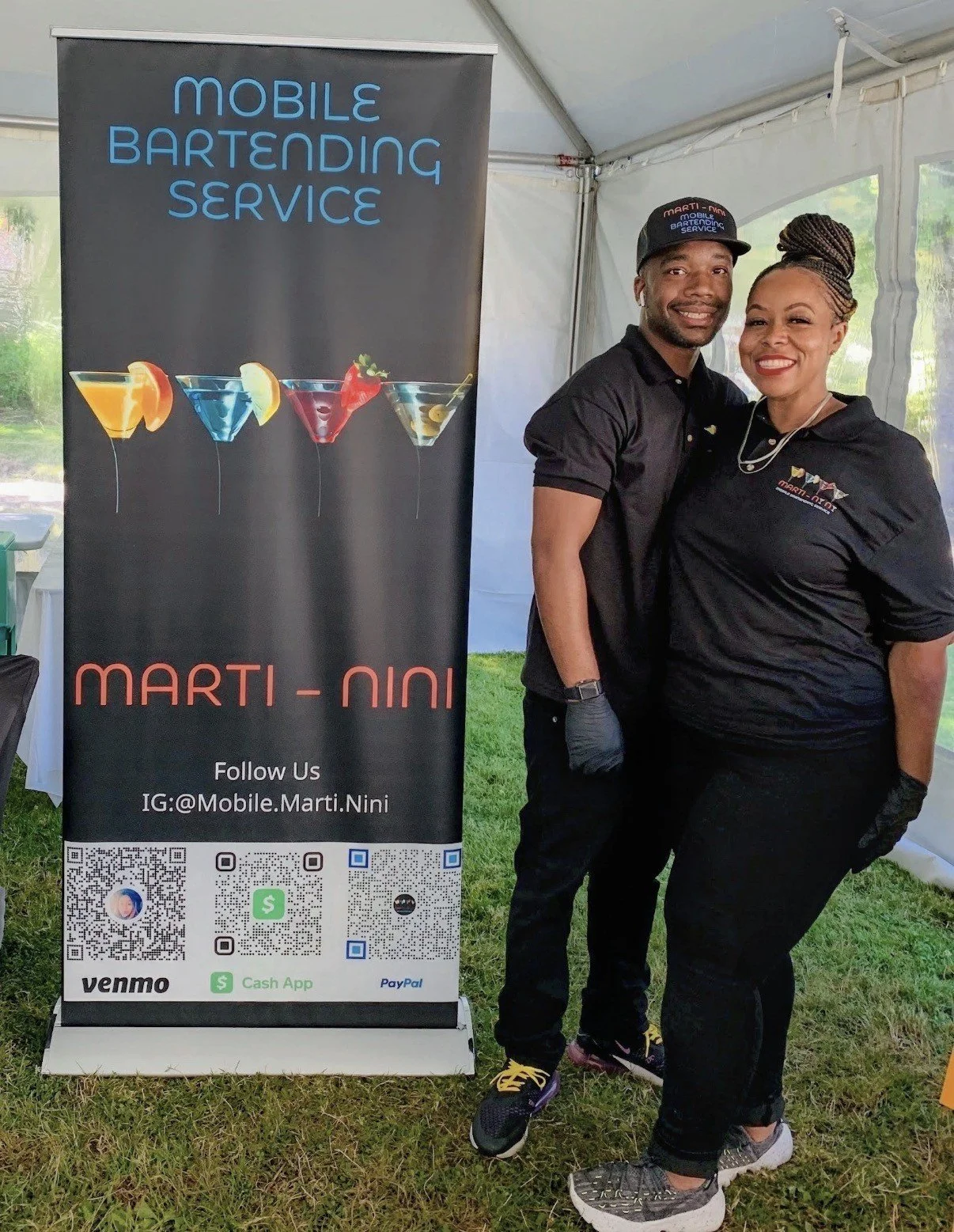 NiNi and her husband beside the Marti NiNi mobile bartending banner