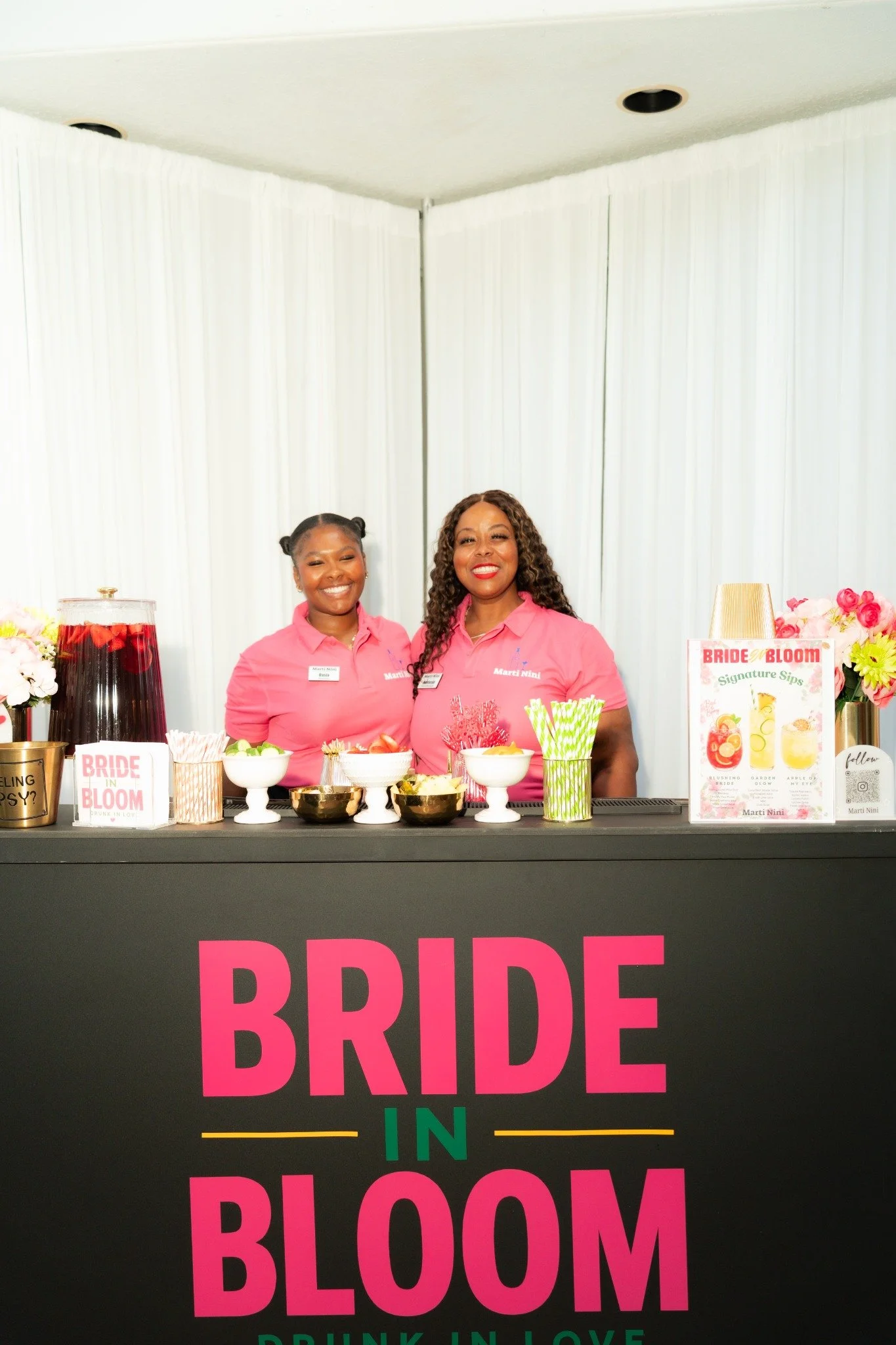 Marti NiNi bartenders in pink uniforms behind the Bride in Bloom bar