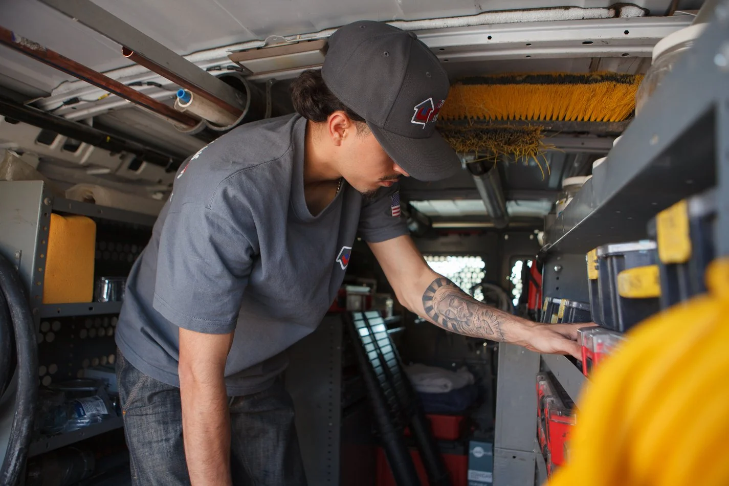 Ser Plumbing plumber reaching for equipment in the van
