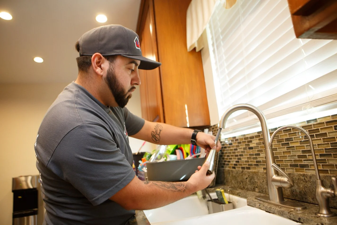 Ser Plumbing technician servicing a kitchen faucet