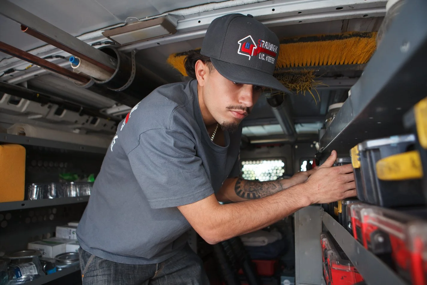 Ser Plumbing plumber handling drain machine equipment in the van bay