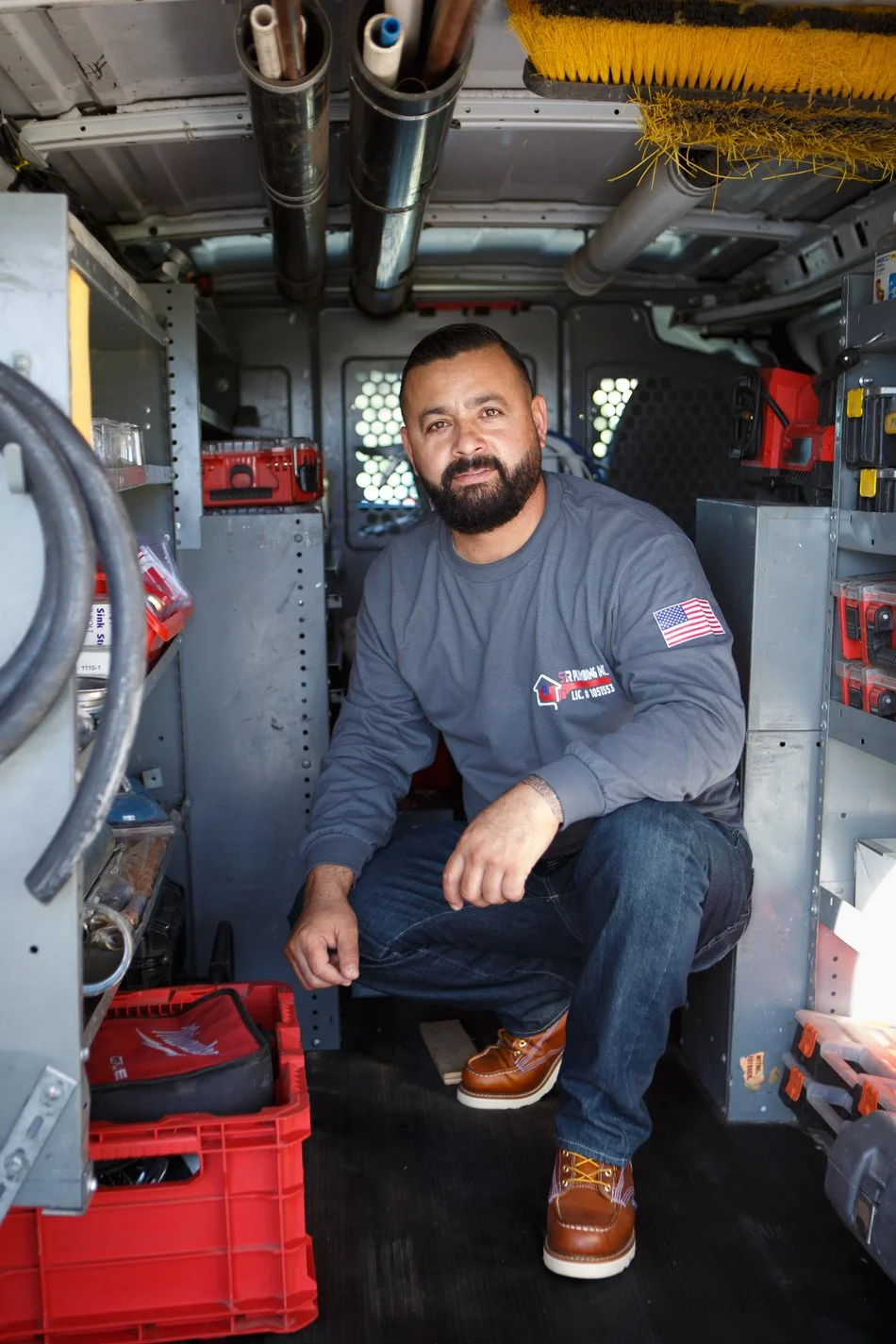 Ser Plumbing owner beside the service van, license and phone number visible