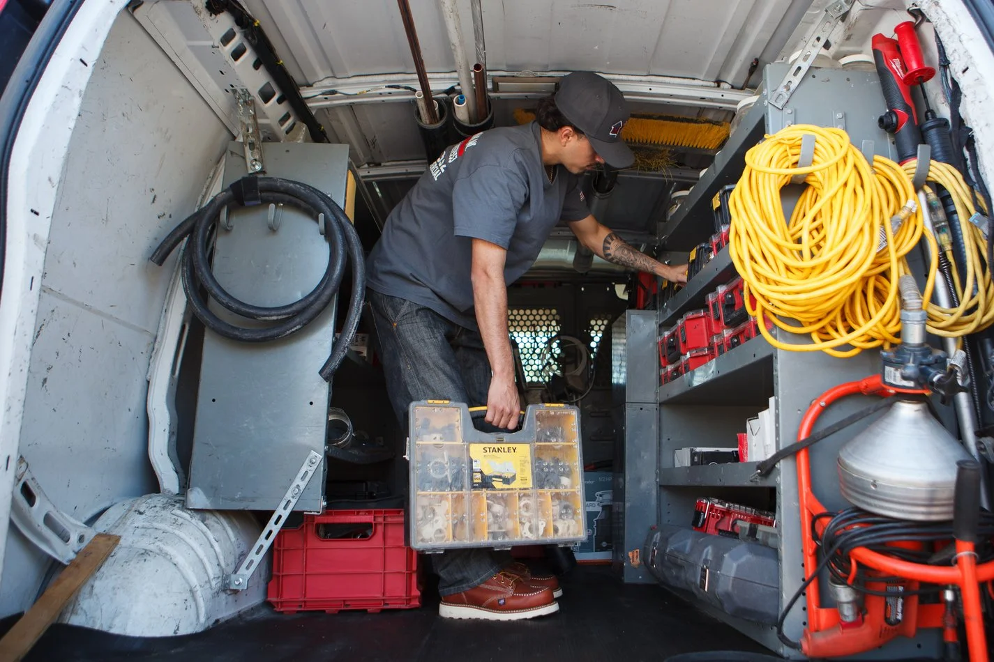 Ser Plumbing plumber selecting tools from the van bay