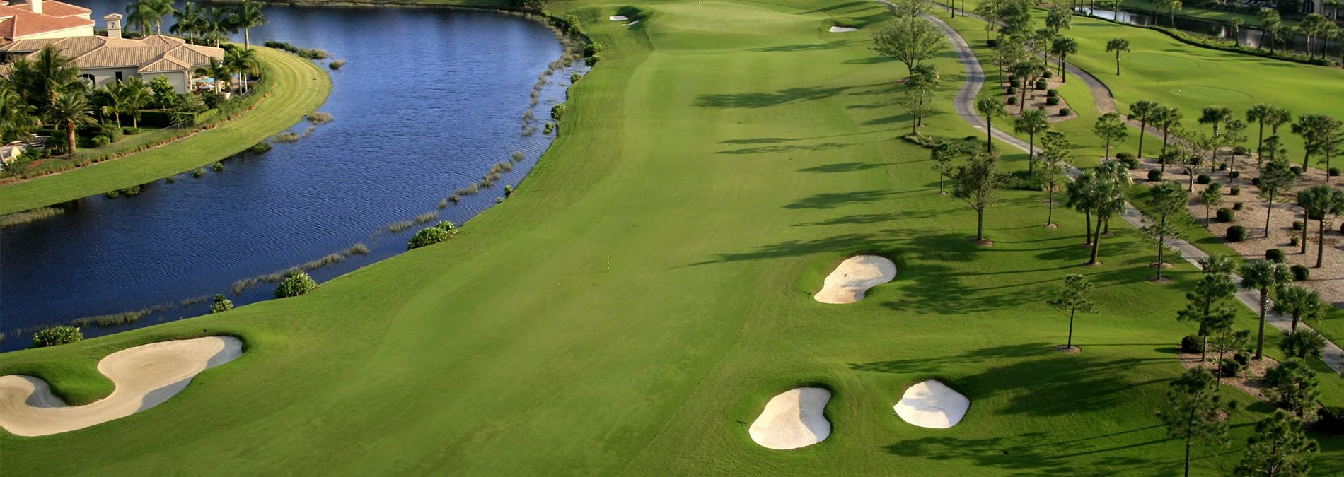 Aerial view of the resort golf course grounds with lakes, bunkers and coastal condo buildings near Longboat Key, Florida