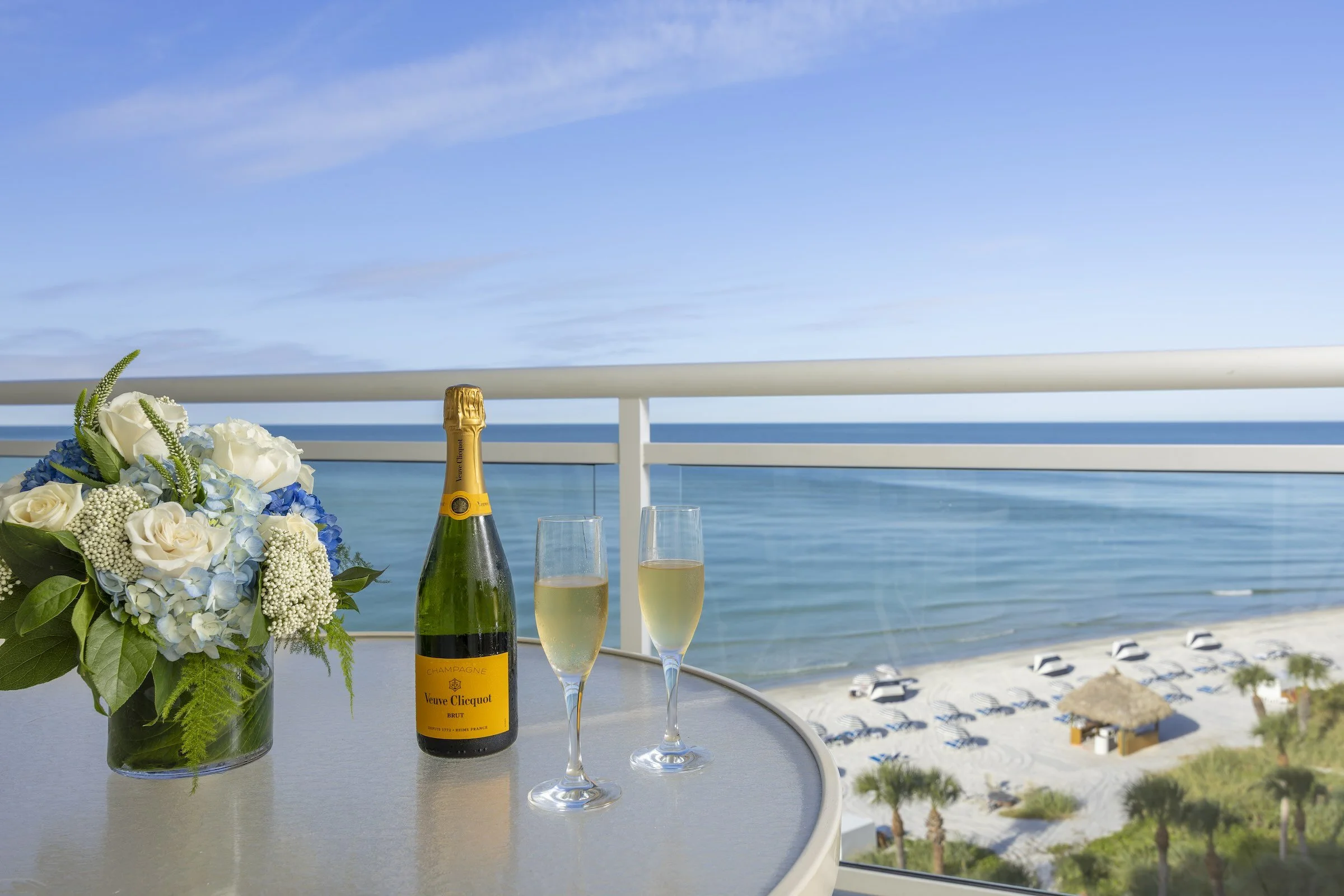 Champagne glasses on a private guest balcony overlooking the water at The Resort at Longboat Key Club