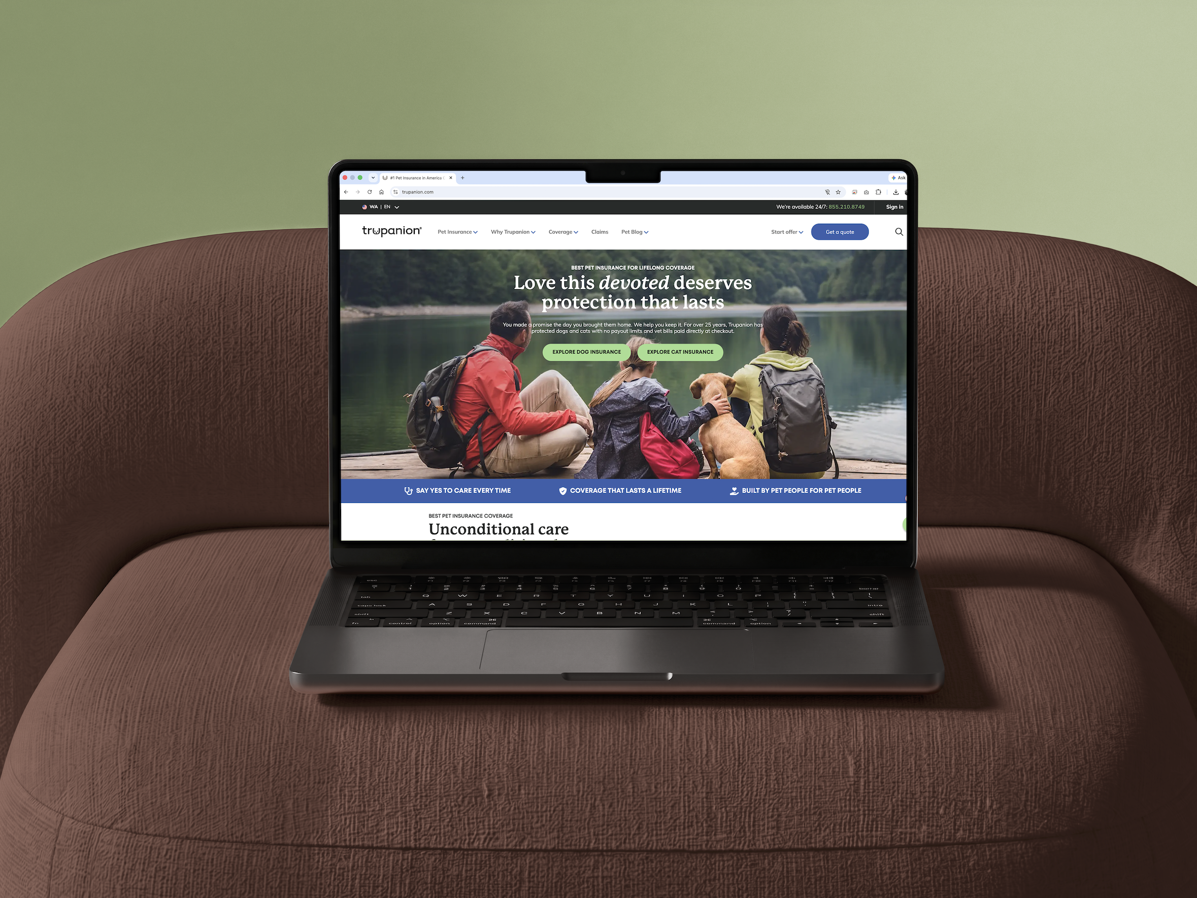 A laptop on a rust boucle sofa showing the redesigned Trupanion homepage