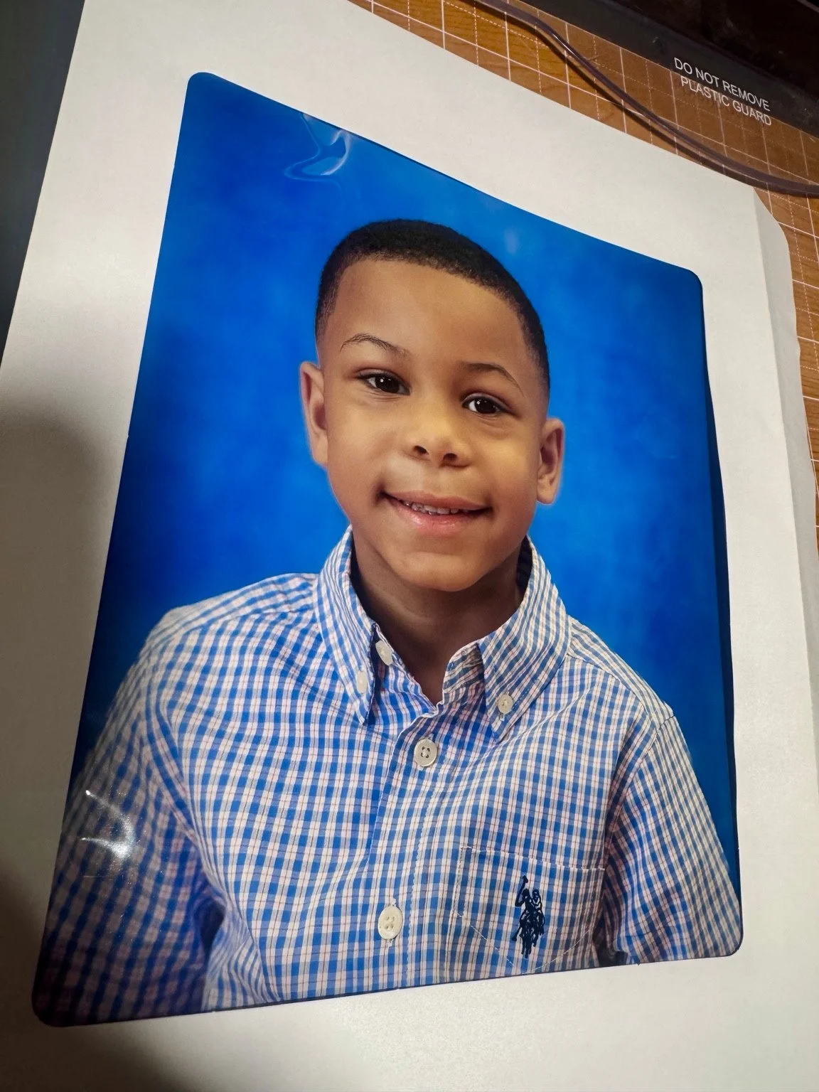 Photograph of a printed Allen Village student portrait on a cutting surface