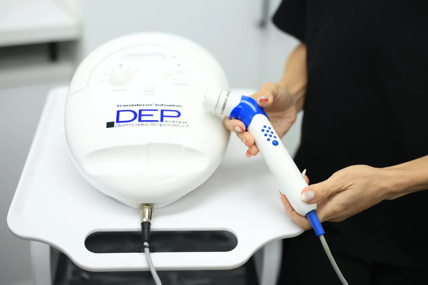Clinician holding the handpiece of an aesthetic treatment device