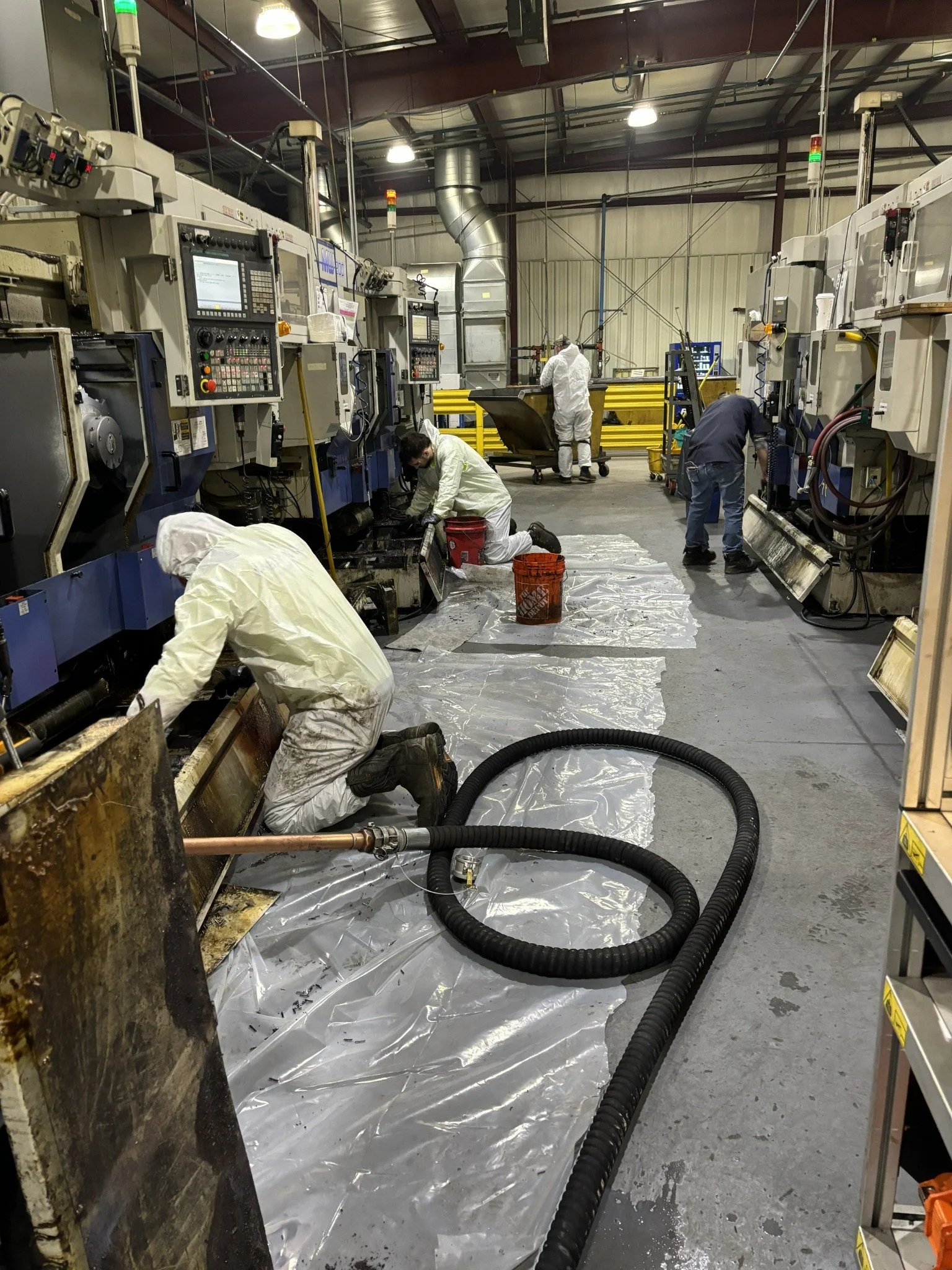 Environmental technicians cleaning industrial machinery