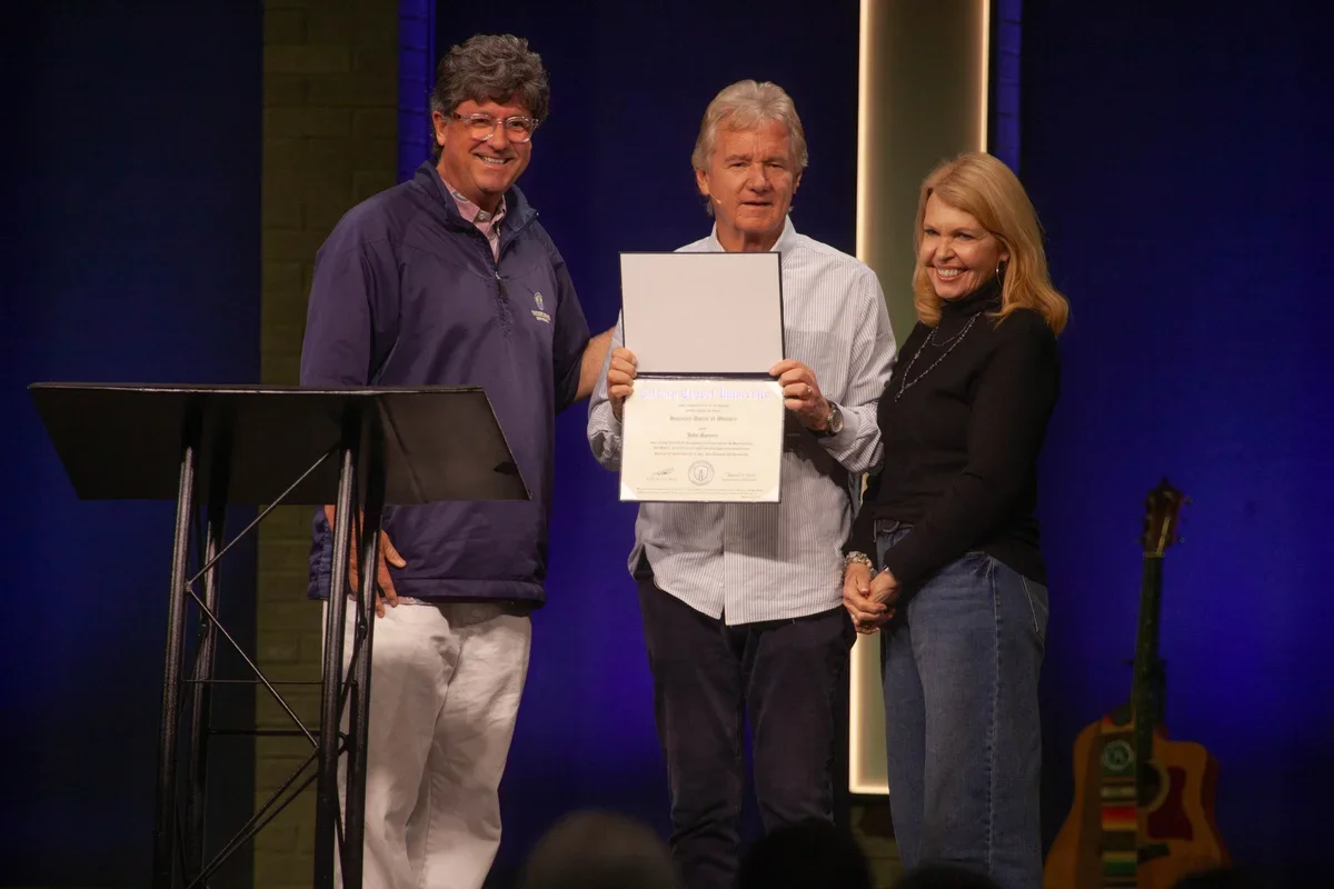 John Spencer holds an honorary doctorate certificate at Calvary Chapel Gulf Breeze.