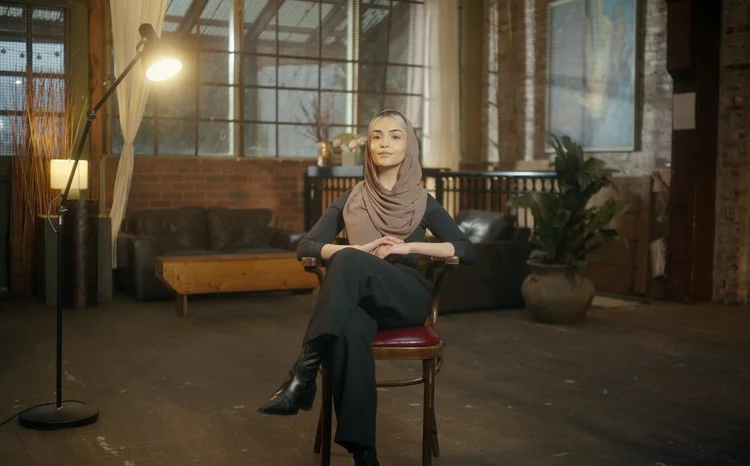 A woman seated in a softly lit room for a Ruh Care interview.