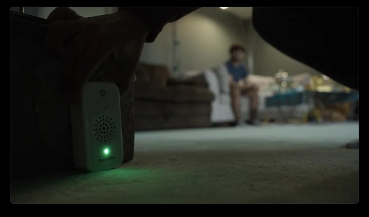 A Quayside Traders device glowing green in a dim living room.