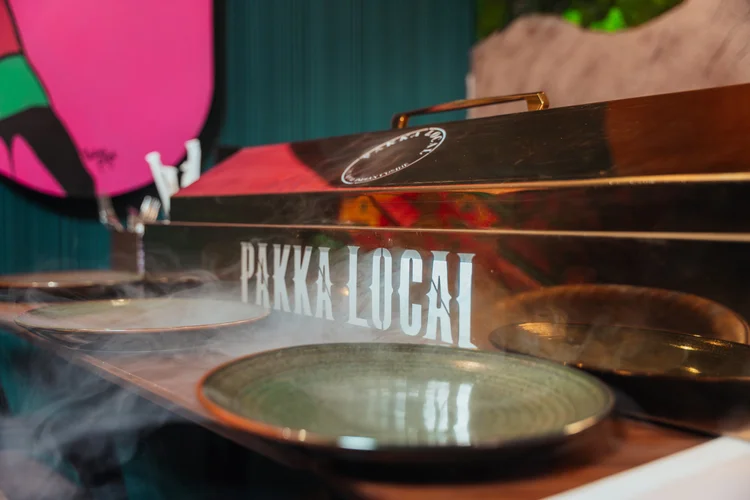 Smoke drifting over plates at the Pakka Local counter.