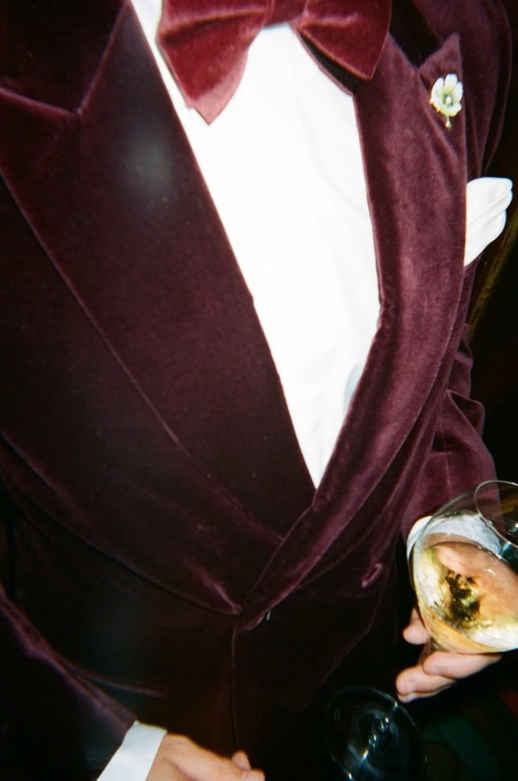A burgundy velvet suit and bow tie
