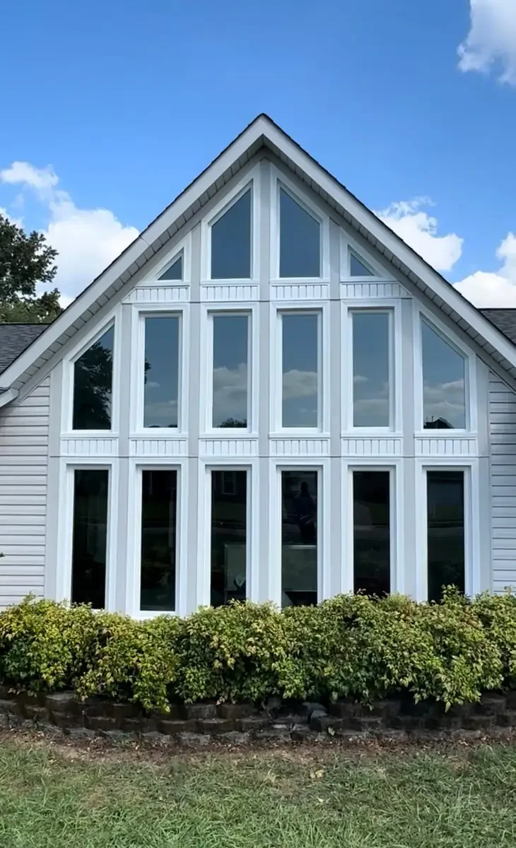 White gable filled with tall and specialty-shaped windows