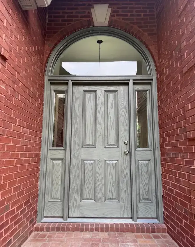 Finished gray entry door with sidelites and a large arched transom