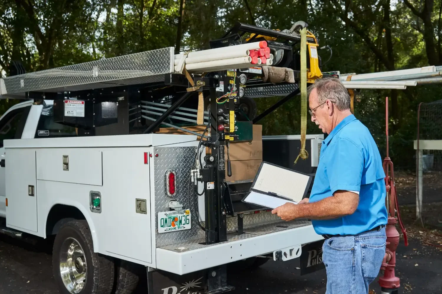 Steven Perry writing up a well pump service call beside the rig truck.