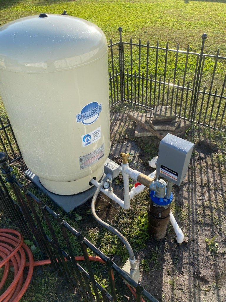 Tank and pump behind a garden fence - Pump Repair Services, Orlando FL