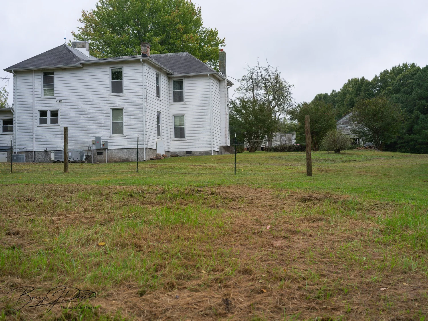 White farmhouse at Hendricks Family Farm viewed across the surrounding grass.