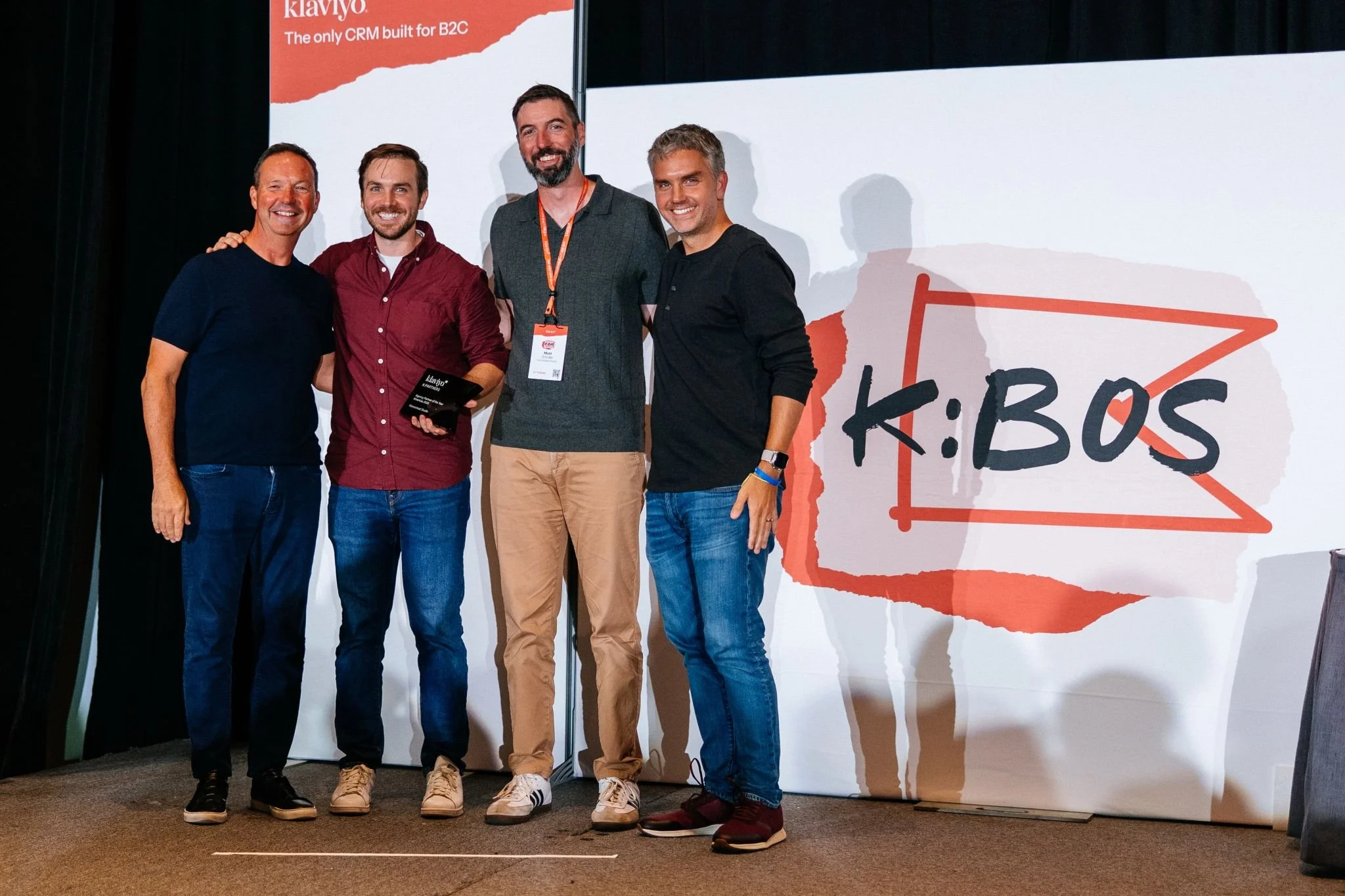 Matt Snyder on stage at Klaviyo’s K:BOS event with three other people, one holding an award plaque