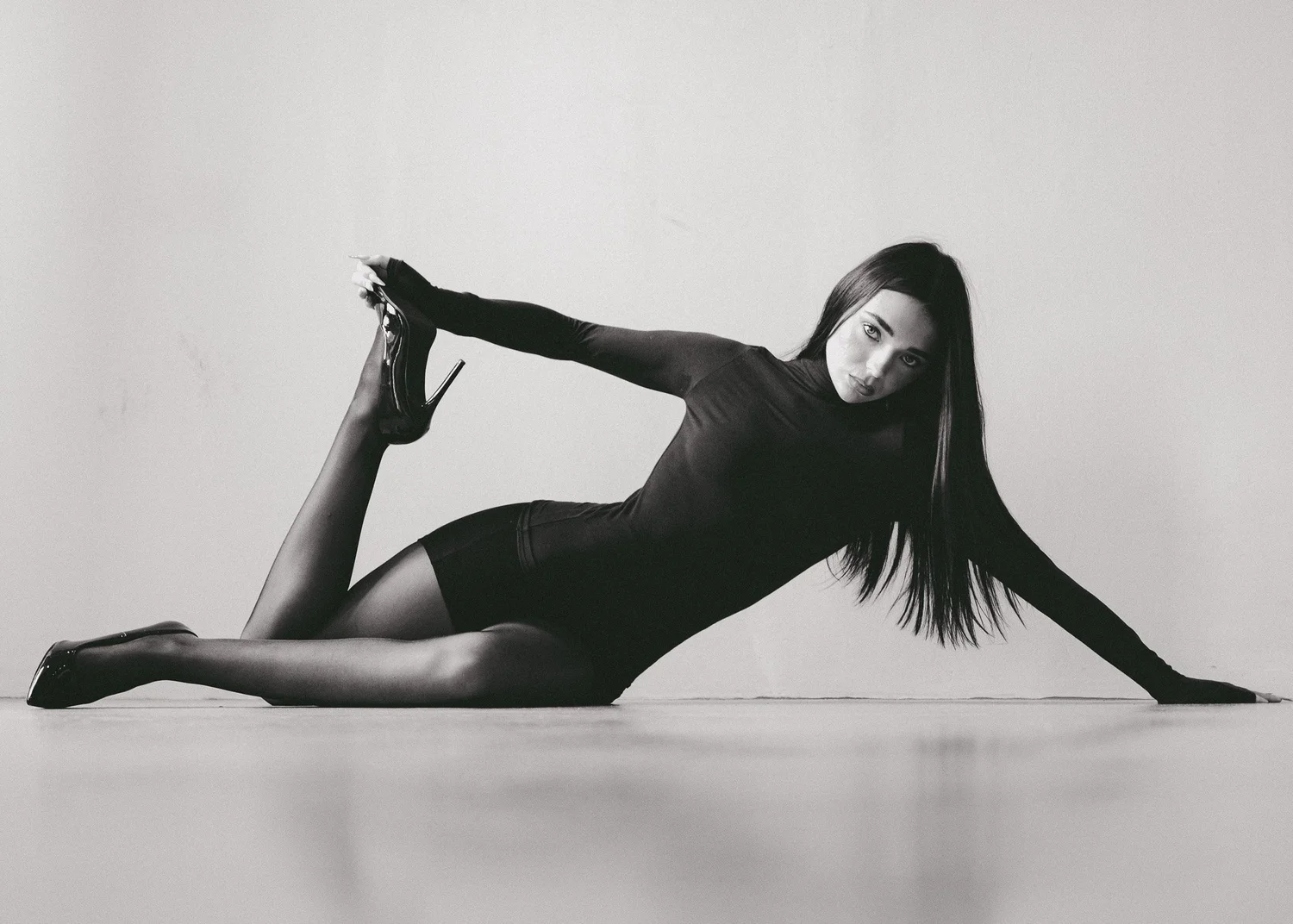 ROSIE × MINT — monochrome sculptural floor pose in a fitted black outfit