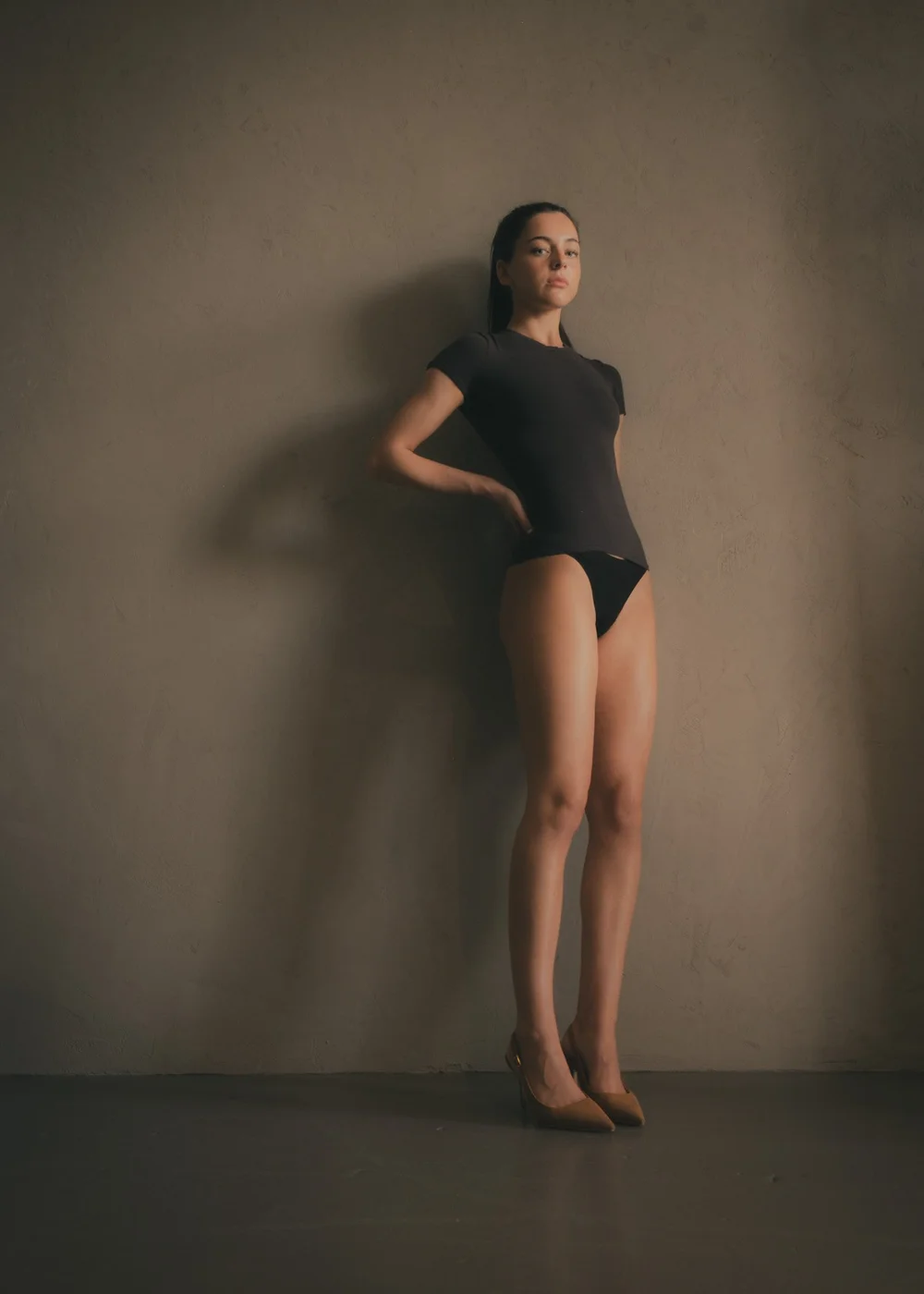 LILY × MINT — Angled full-length fashion pose in a fitted black T-shirt and tan heels, photographed by CAMR Visuals.