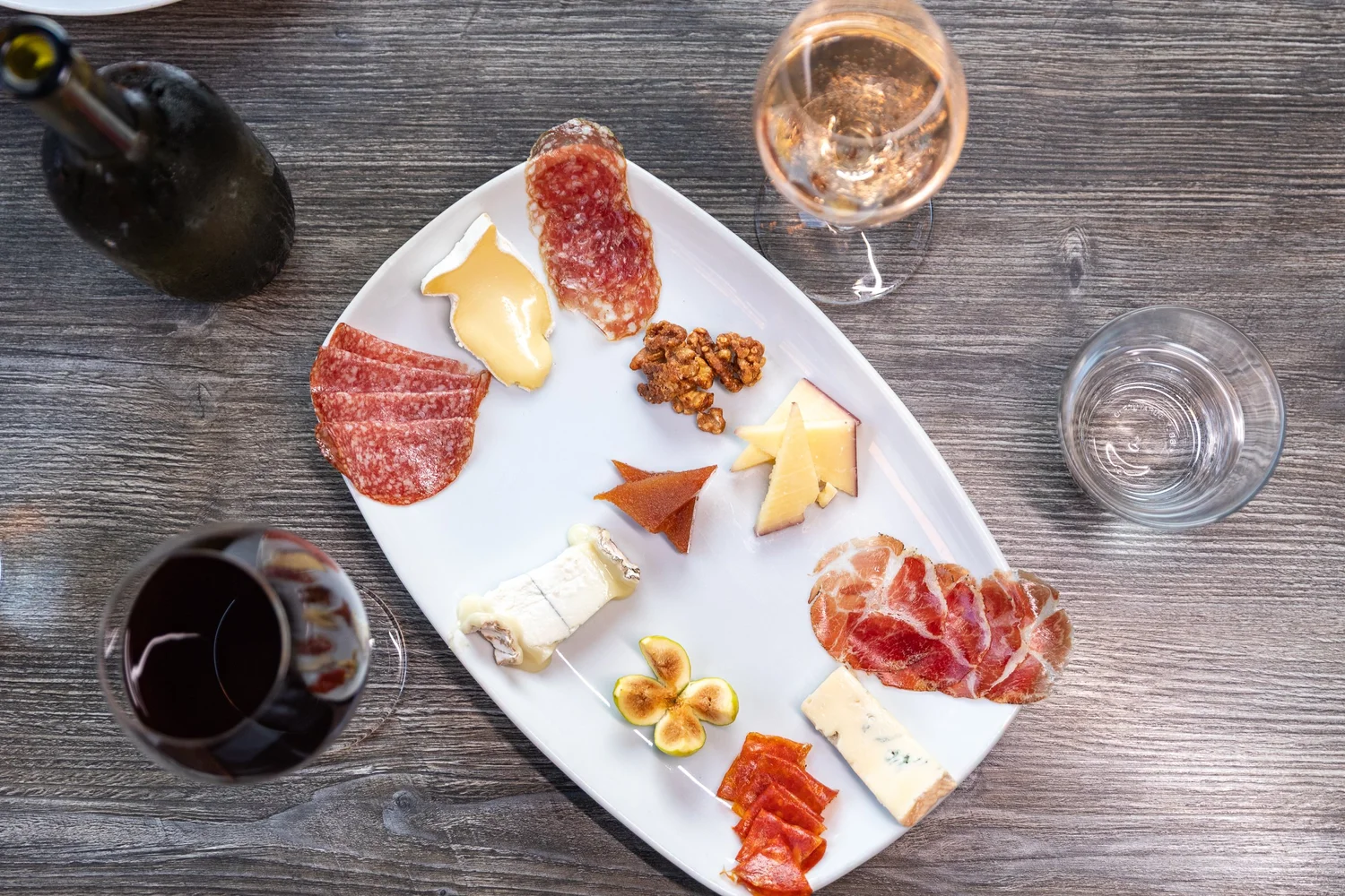 A charcuterie and cheese board with a glass of rosé at Bacchus