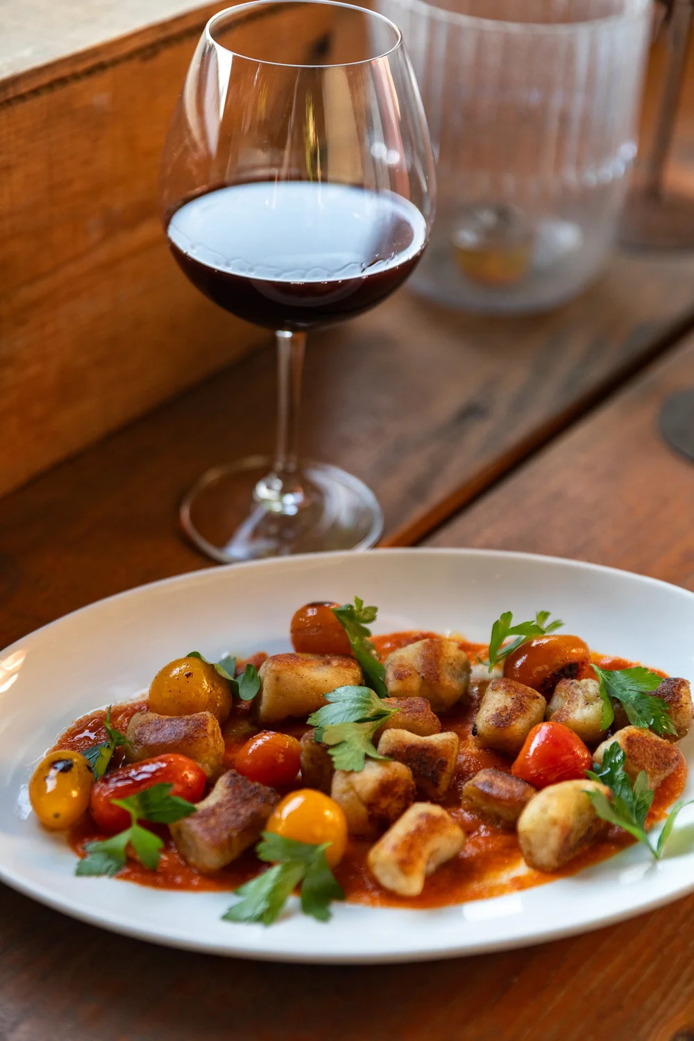 A plate of food with a glass of red wine at Bacchus