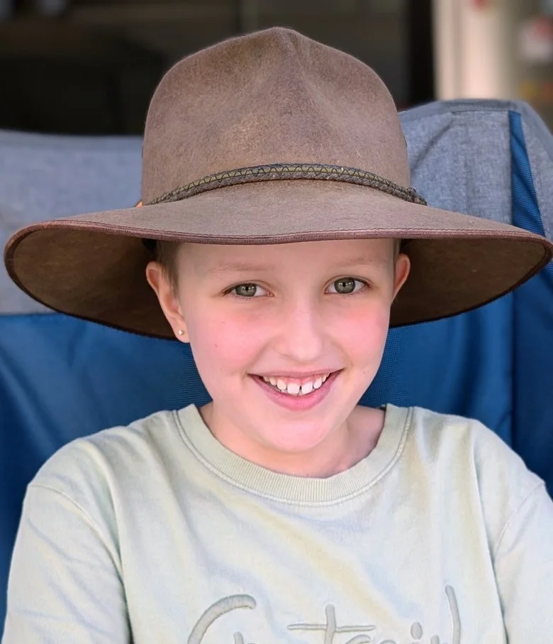 Beatrix in a wide-brimmed hat, grinning