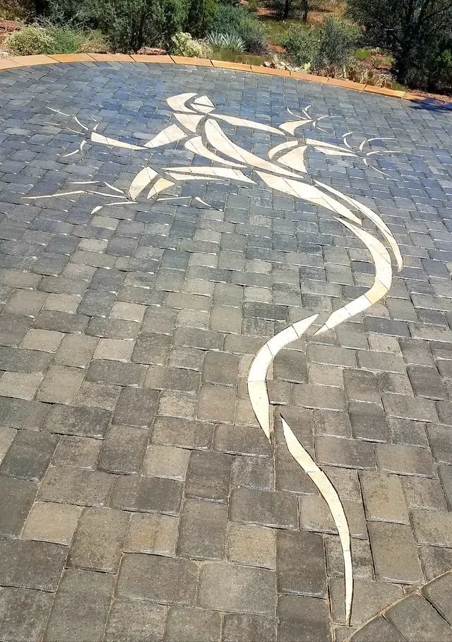 Custom gecko paver inlay cut into a stone walkway