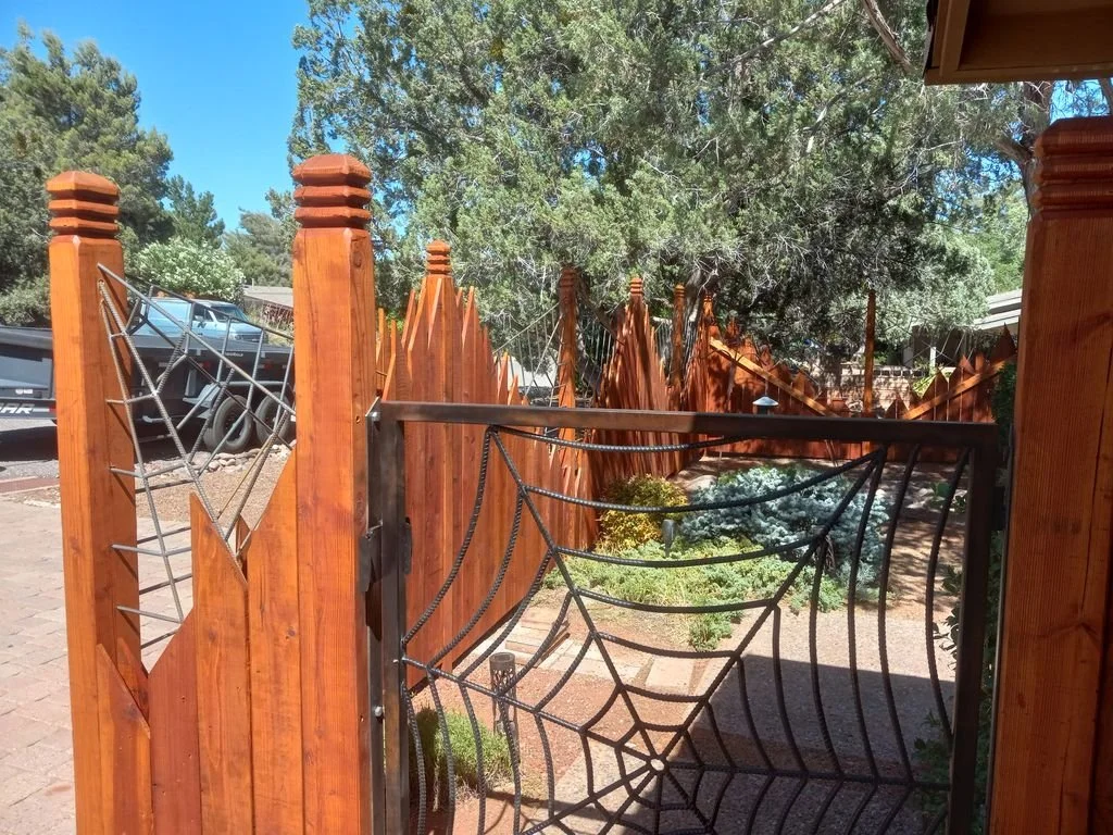 Custom wood fence with a welded steel spiderweb gate