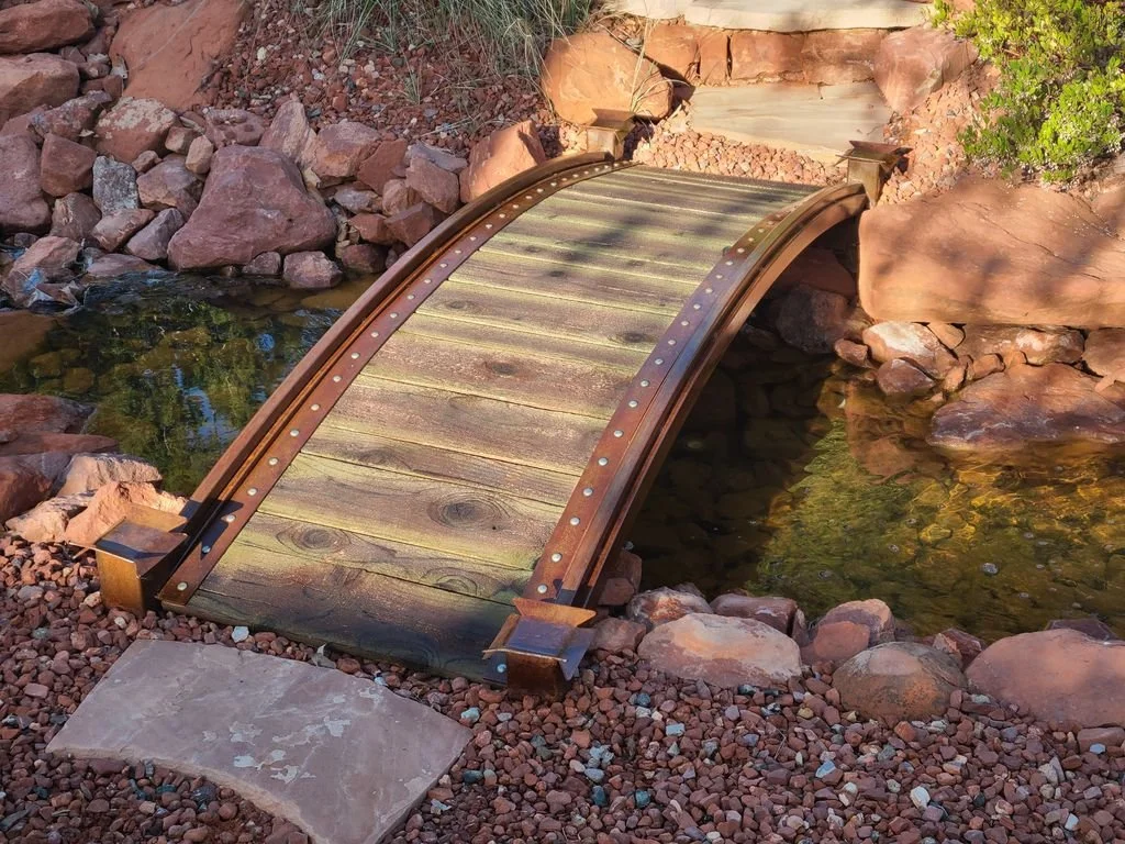 Custom steel and wood bridge over natural stone stream