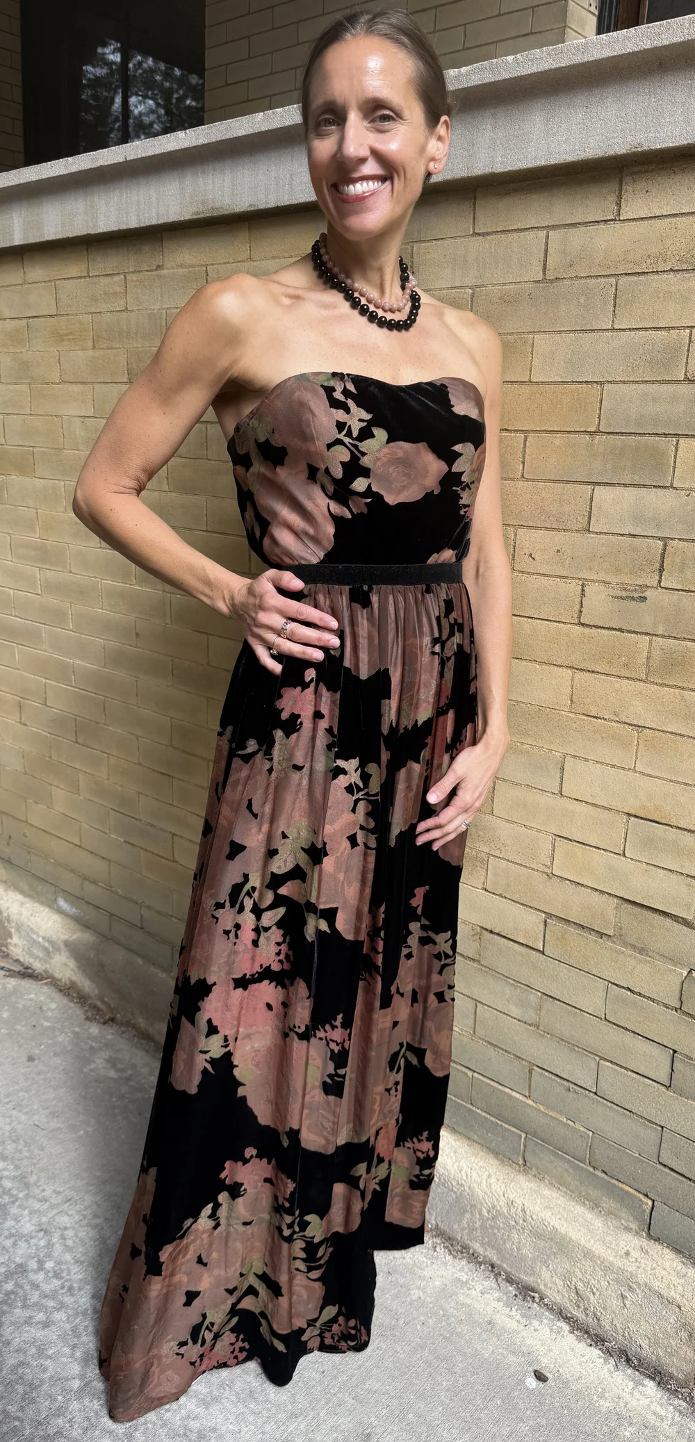 Black and pink bead necklaces styled with a strapless black-and-rose floral dress.