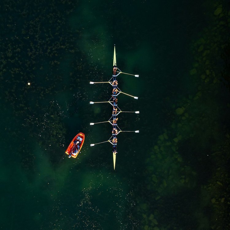 Yellow eight with coach launch on green water