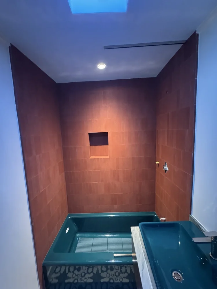 Terracotta and teal bathroom installation — project view.