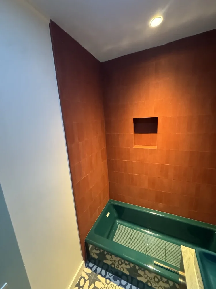 Terracotta and teal bathroom installation — project view.