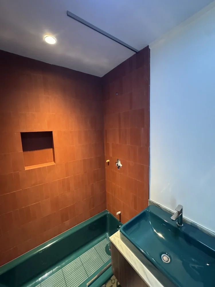 Terracotta and teal bathroom installation — project view.