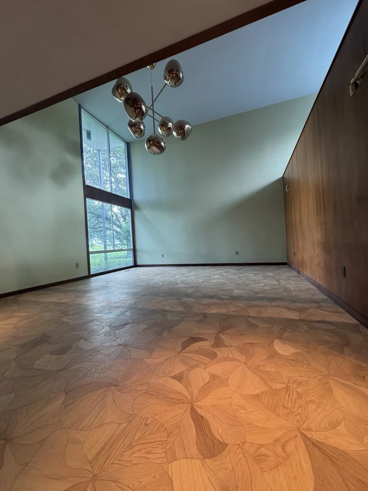 Decorative wood-tone patterned flooring in a wood-paneled room.