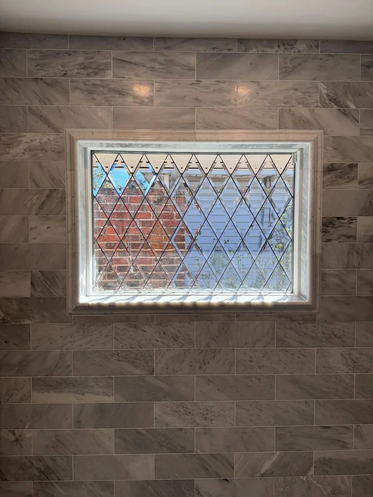 Marble bathroom with brass details — EC Construction project photograph.