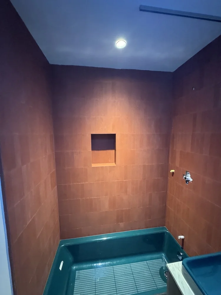 Terracotta and teal bathroom installation — project view.