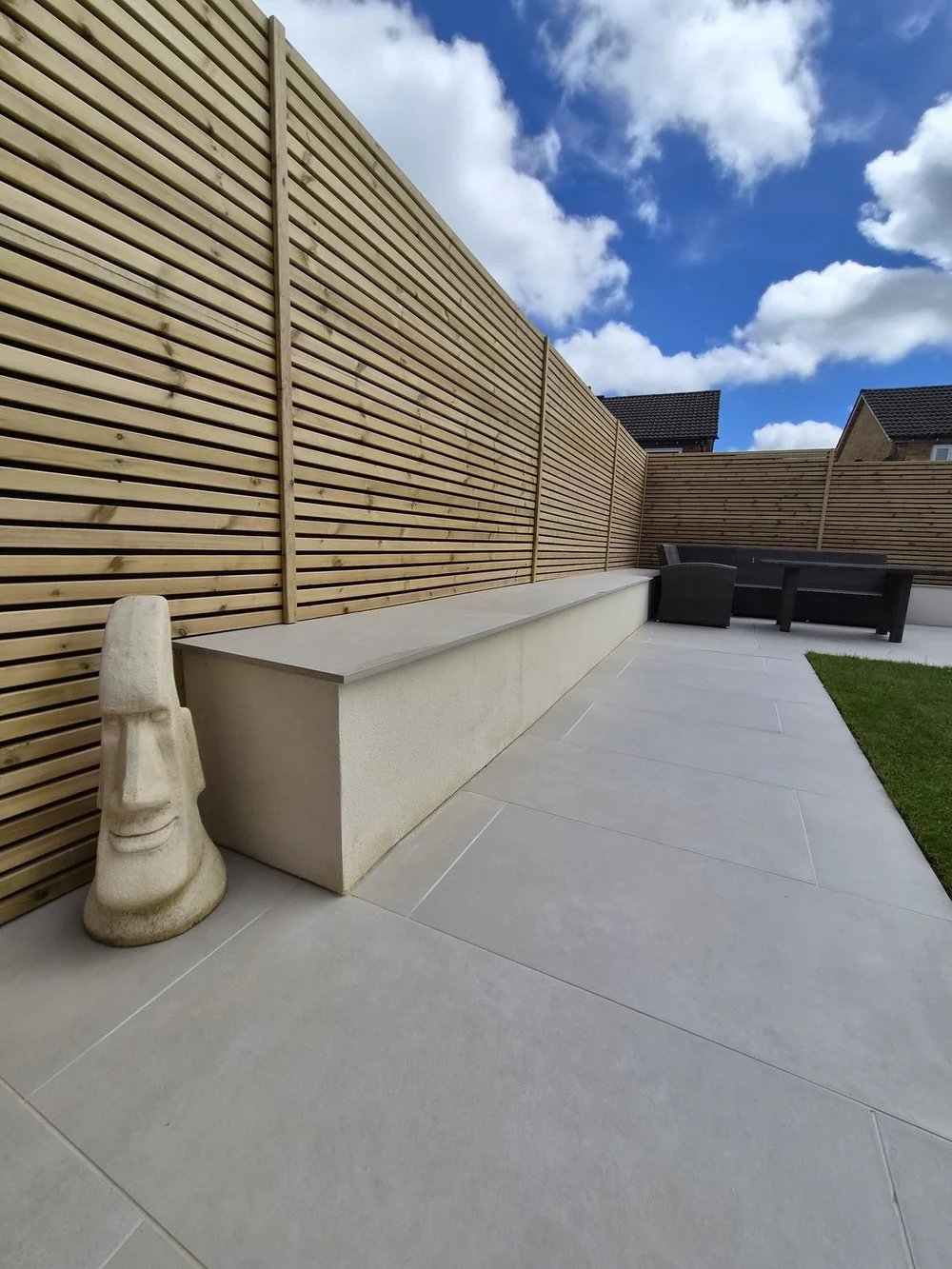 Built-in seating wall and porcelain patio in a Llantwit Fardre garden